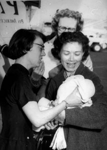 Molly in 1959, placing a baby in her adoptive mother’s arms after a long journey from Korea to the U.S. 