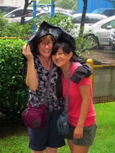  Huddled under a raincoat, Grace and her mom stand in the same spot where Ms. Pong united the two of them 14 years ago. 