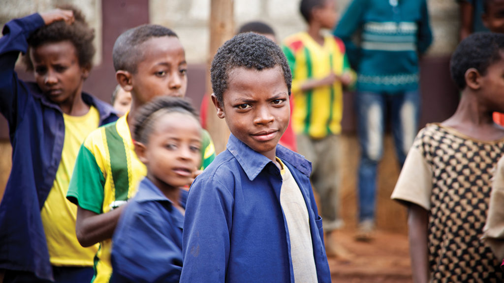 Children line up for a lunch of cabbage, rice, stew and injera, a spongy Ethiopian bread. Before Holt began providing daily lunch for the students at Yesus Mena, they had one slice of bread and one cup of tea every day.