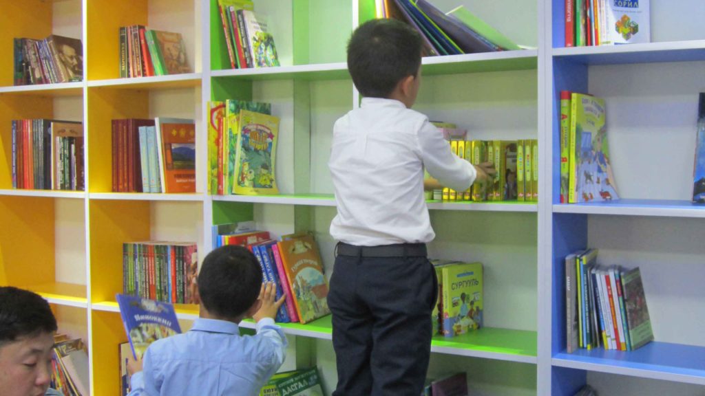 Boy looking through books on shelf
