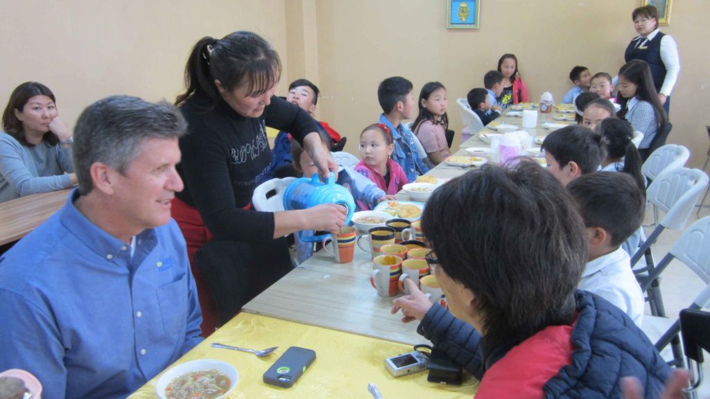 Children eating lunch with Phil Littleton