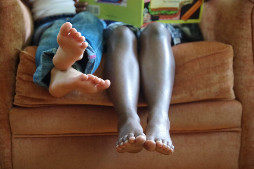 Schell children reading some of the 21 books for internationally adopted kids