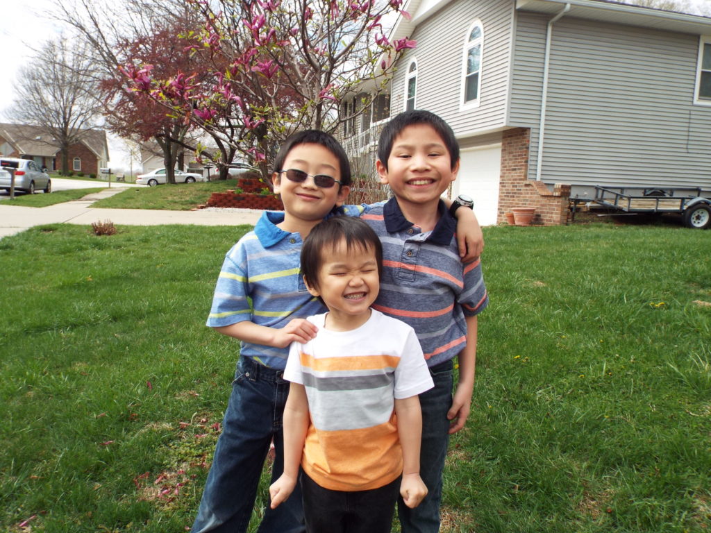 Spencer standing with two other children smiling