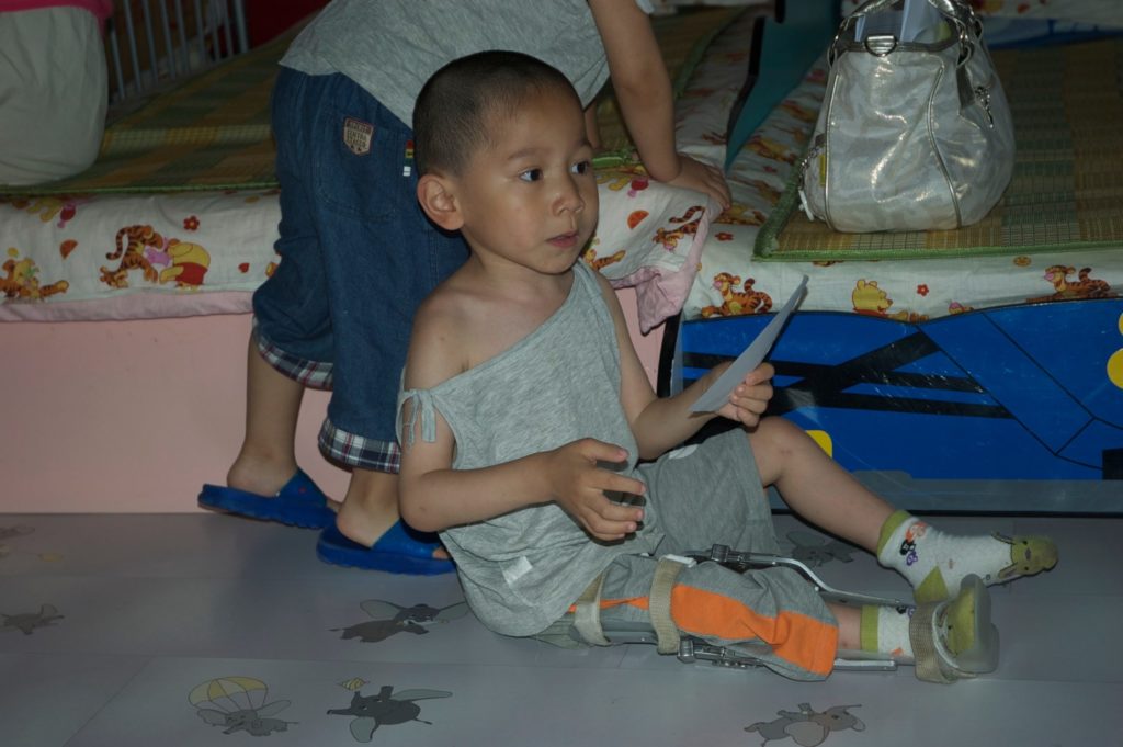 Photo of Spencer in orphanage with brace on his leg. 
