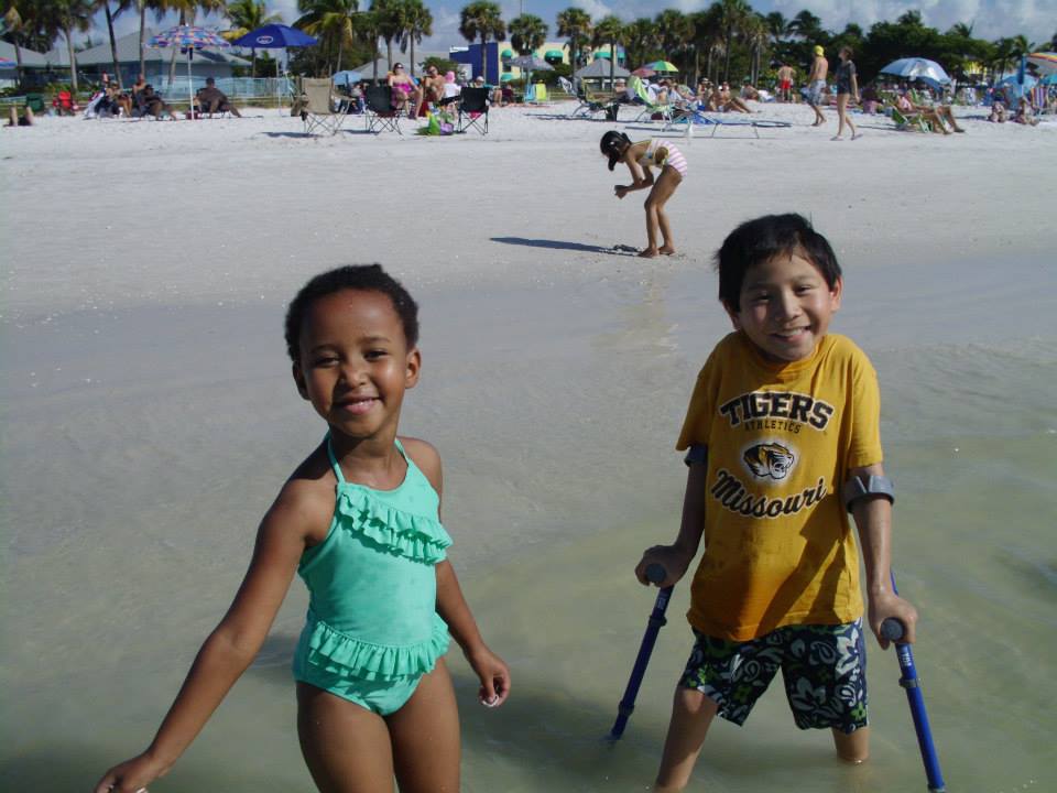 Holt adopted child Spencer playing in the ocean with his younger sister
