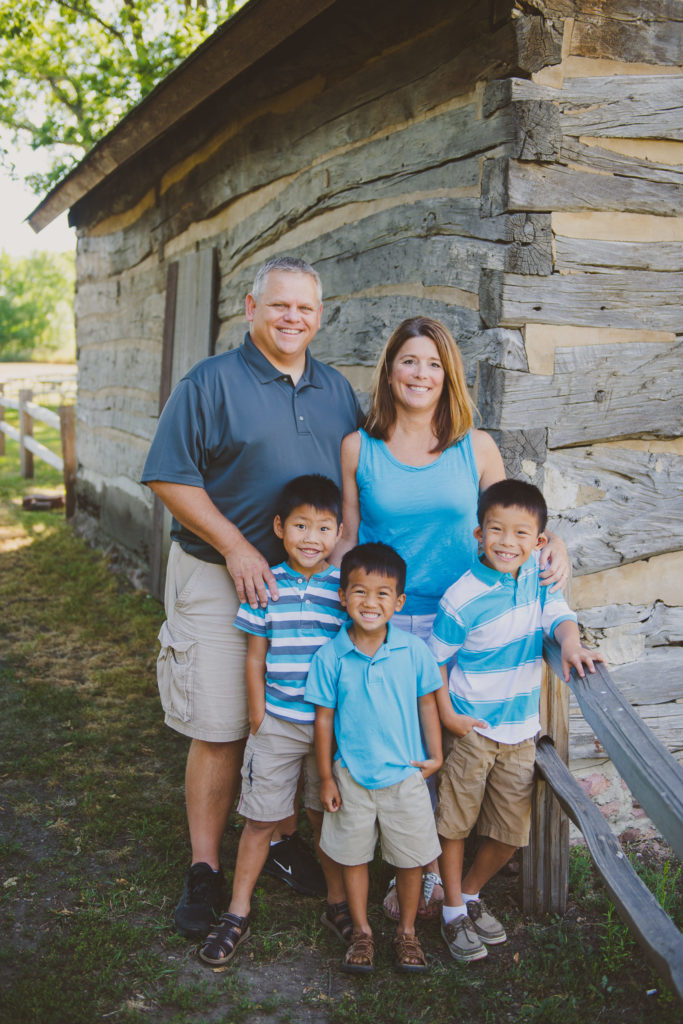 Photo of Diane and Troy Sturgeon standing with their three adopted sons.