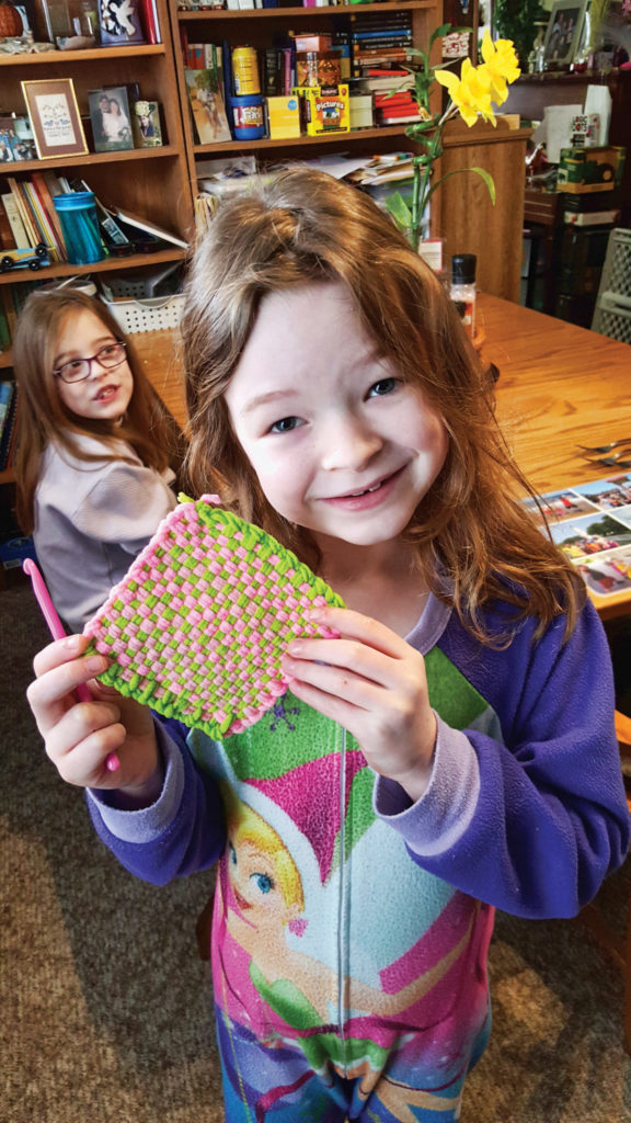 Madison holding up one of the potholders she made.