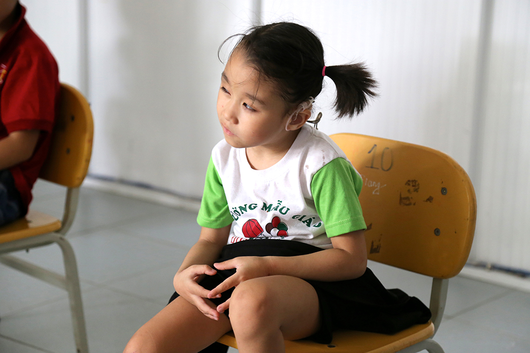 Giang sitting in a chair at the Kianh Foundation — a school and day care center specifically for children with special needs.