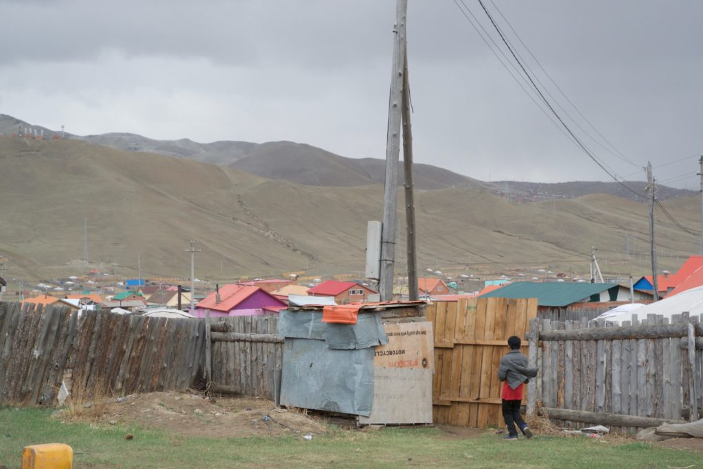 Amin-Erdene's brother outside the latrine shared by three families on this property.