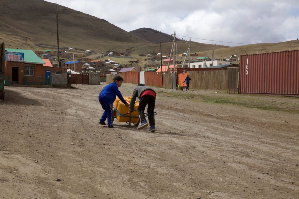 Amin-Erdene's older brothers push a cart with water up the hill to their ger.
