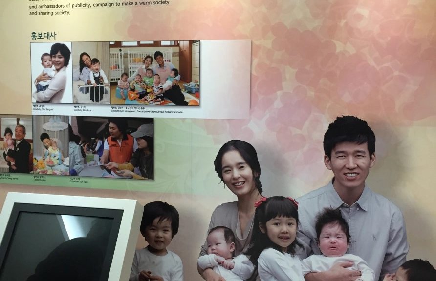 wall display with photos of a Korean family and their children