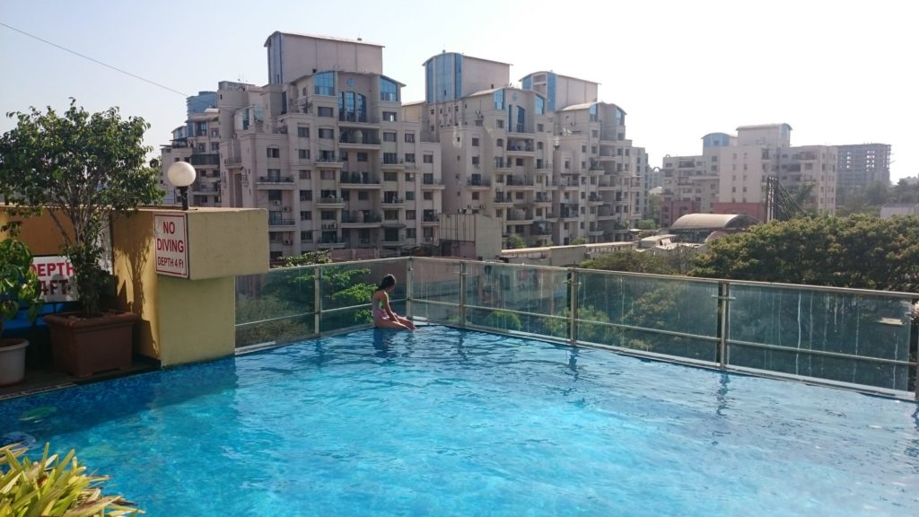 Photo of hotel pool and surrounding buildings in India