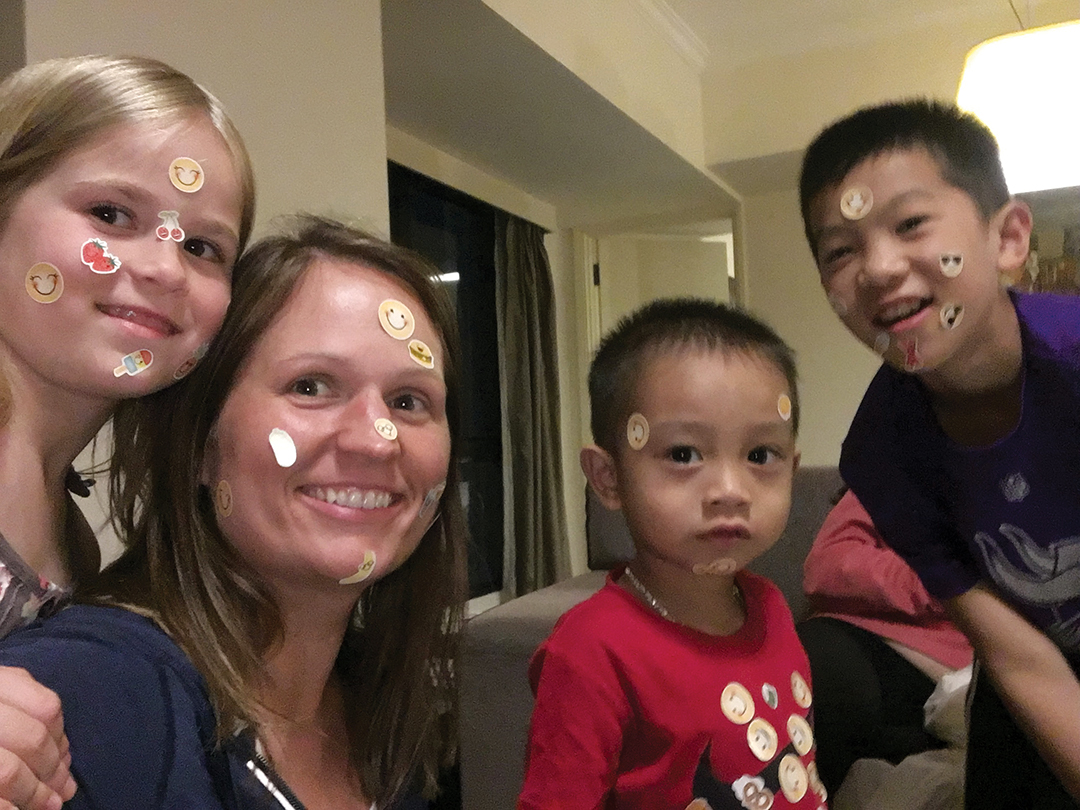 A family playing with stickers. It's a great game for bonding and being prepared with bonding activities is one of the ones you can prepare for adoption.