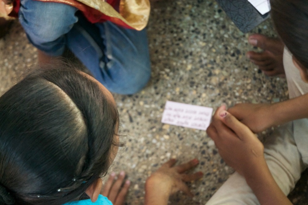 Groups of boys and girls sit in small groups discussing issues about dating, abuse and gender equality, which they read off hand-written note cards in an effort to end domestic violence.