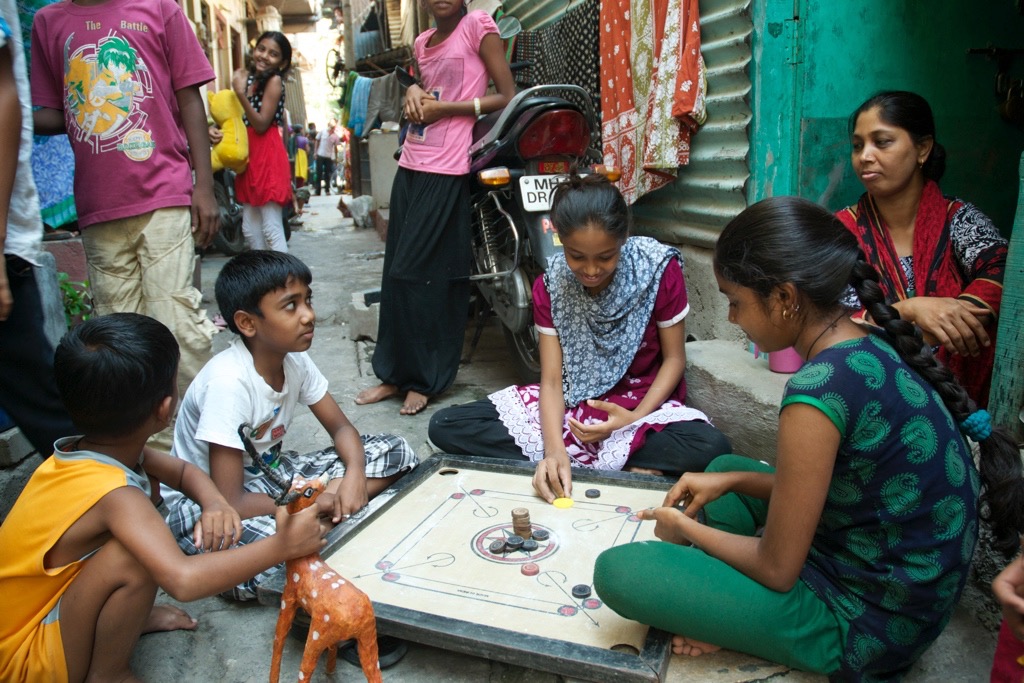 Raji's classmates play a game in the alleyway where they live.