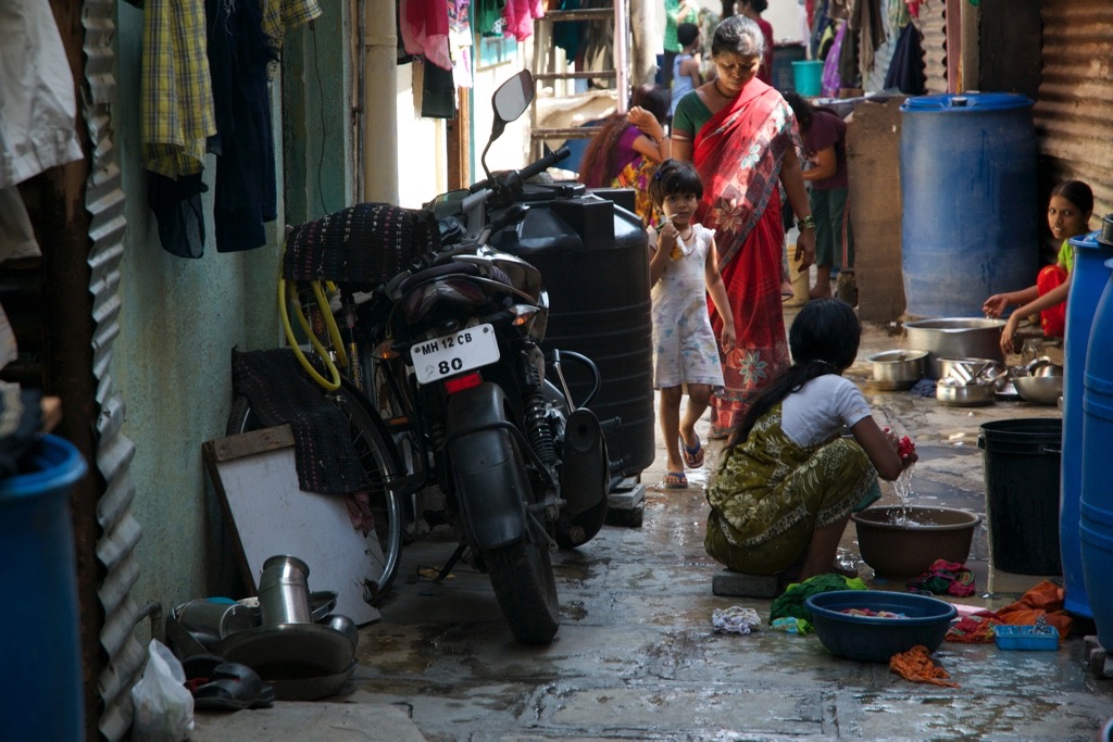 Women do their wash by hand in the alley where Raji lives.