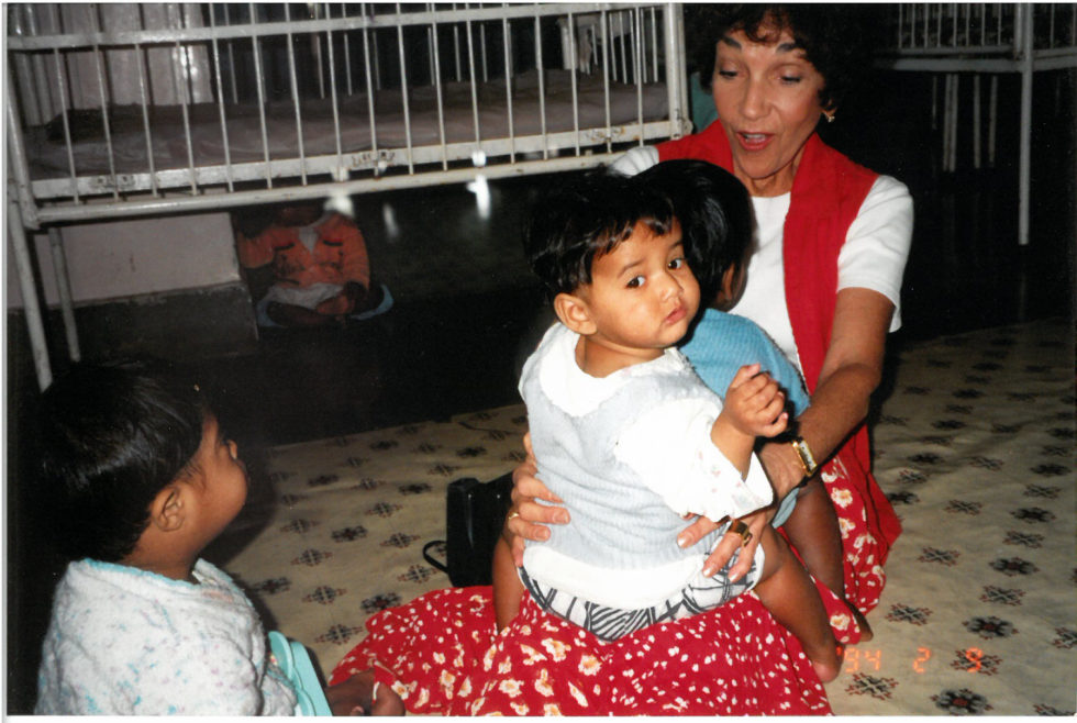 Char and Phillip when they first got to know each other in the care center. Phillip sits in her lap, facing her. At the start of their international adoption story.