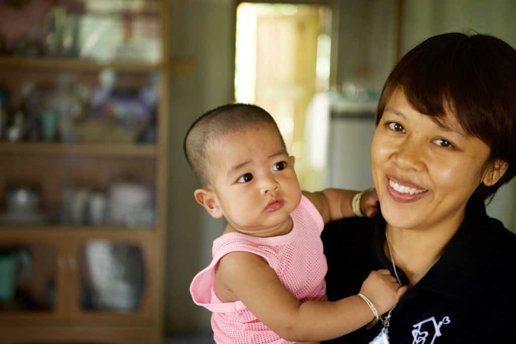 A social worker at Holt holding one of the babies. When you sponsor a child in Thailand social workers work with the family offering guidance and support.