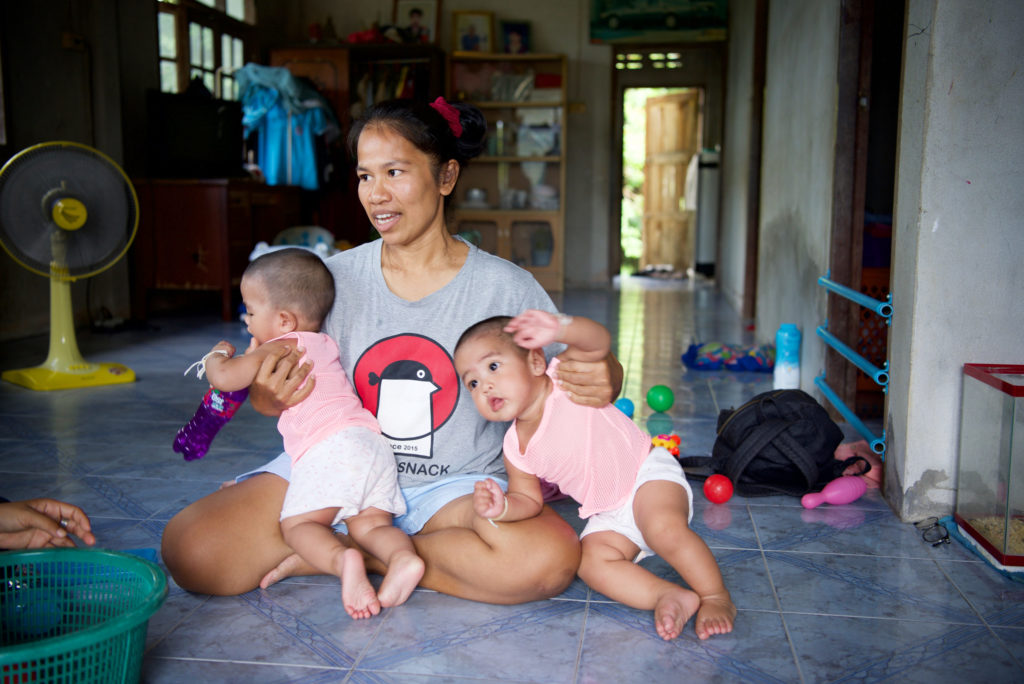 Photo of Ping holding her twin babies.  When you sponsor a child in Thailand you help people like Ping and her sons.