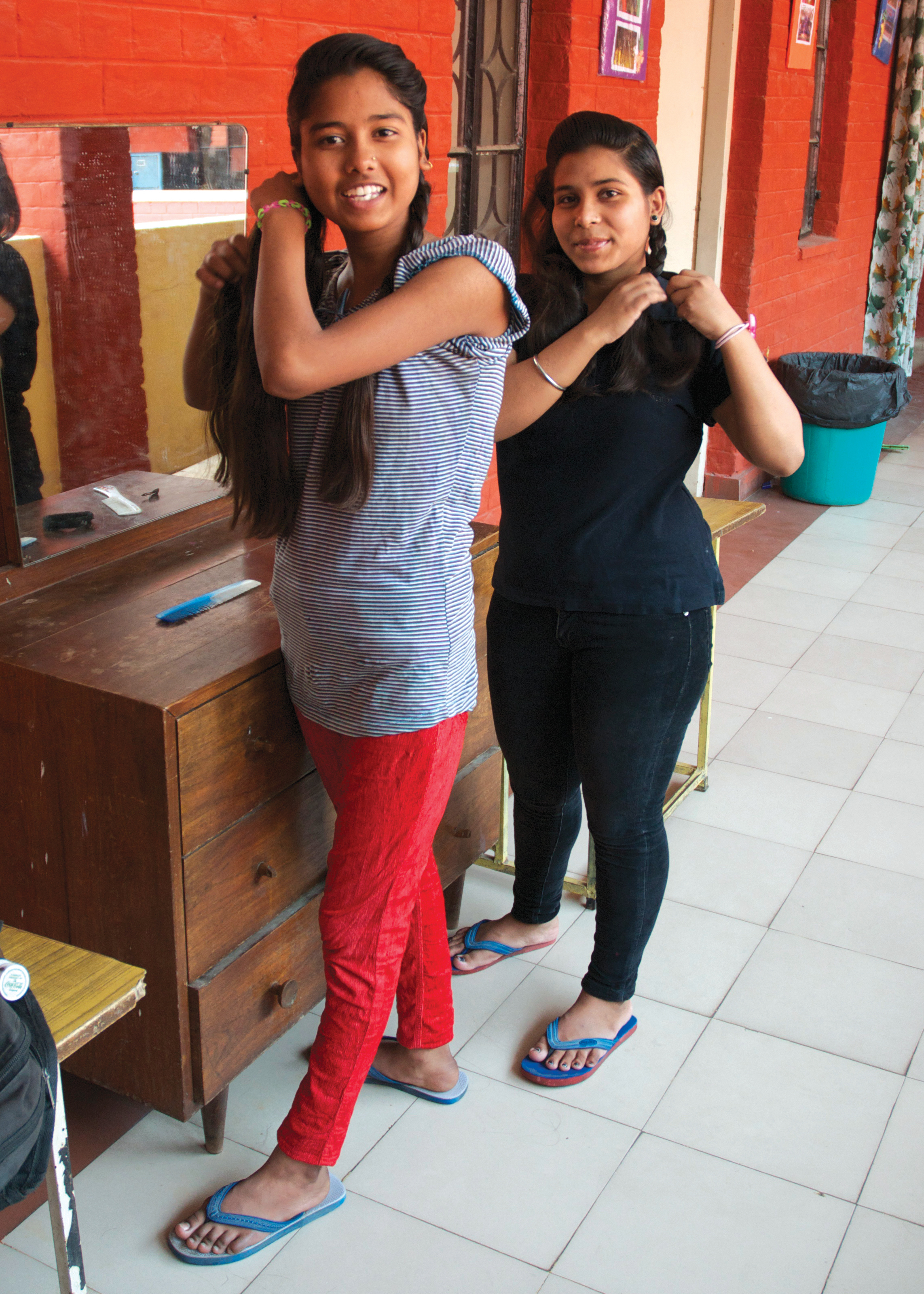 Sponsored girls Preeti in red pants outside her room at the hostel in 2015.