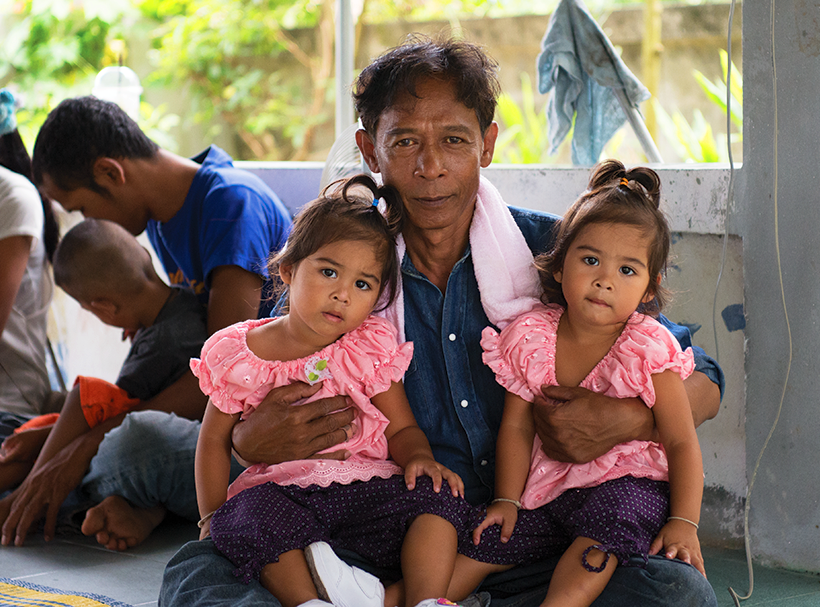 Niran and his twin daughters. Holt sponsored programs in Thailand help this single parent in raising his daughters.