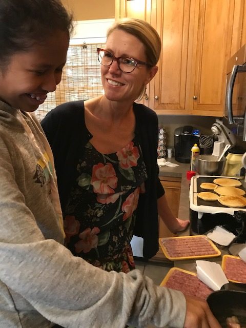 Karen preparing breakfast with one of her older adopted children.