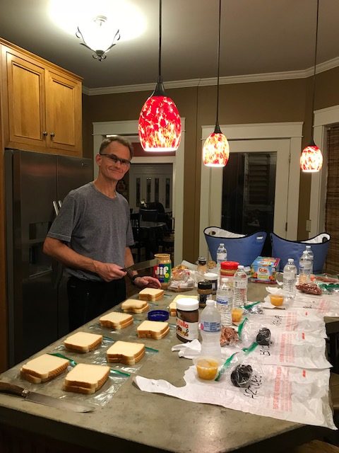 Mike preparing school lunches for several of their adopted children.