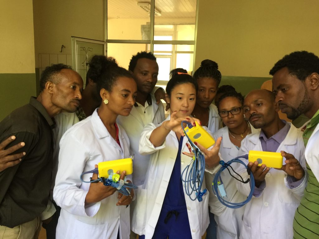 Kayla (center) teaches staff at the Shinshicho Primary Hospital how to use a pulse oximetry monitor.