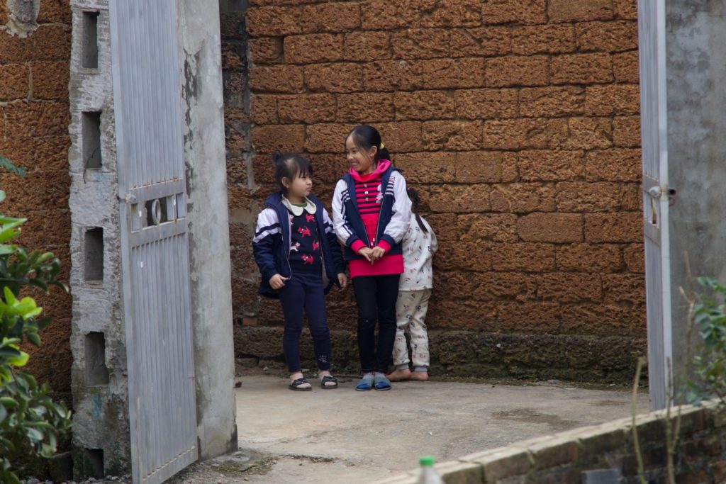 Nam is still in kindergarten, and three of her sisters are in primary school — two of whom are pictured here in their uniform jackets with Nam