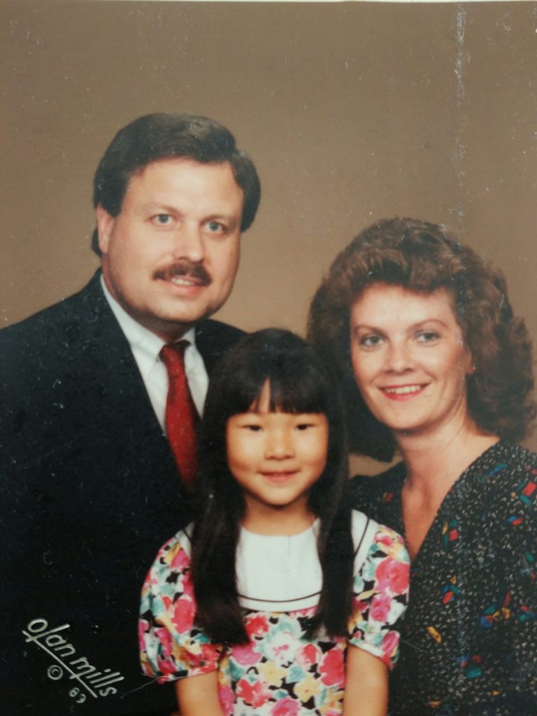 A family photo of Cat with her adopted family, a photo her father kept in his wallet