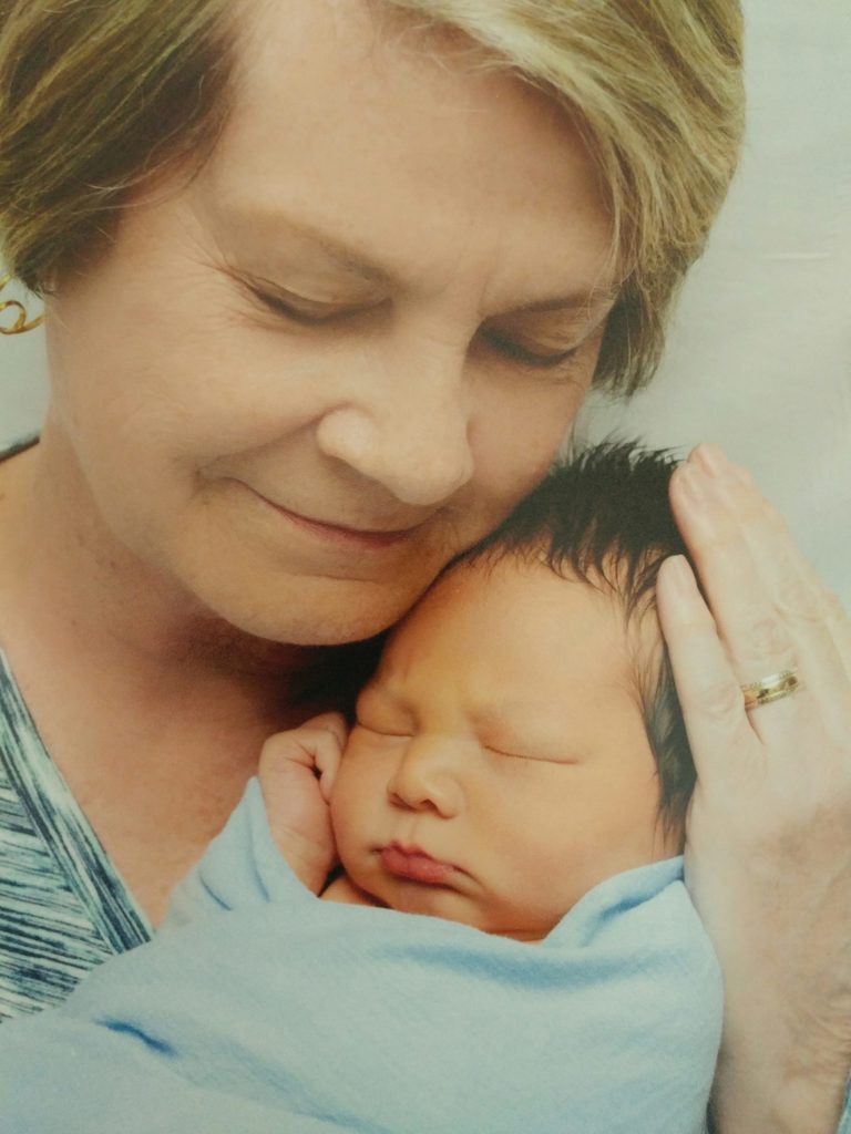 Cat's mom holds her grandson for the first time.