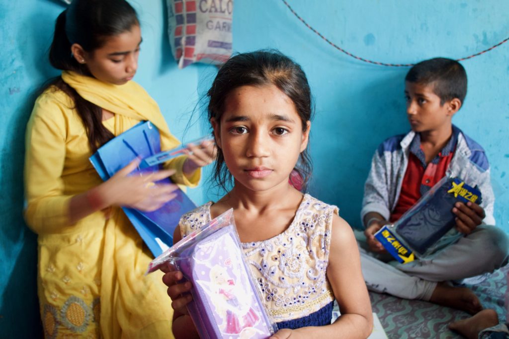 All of Shabnam's children received new school supplies today, and they hold up their favorite new item.