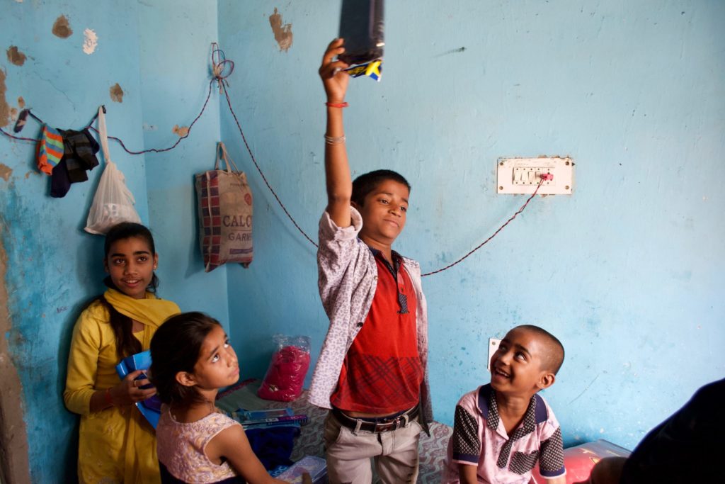 Shabnam's children have new school supplies and are looking at them or holding them up