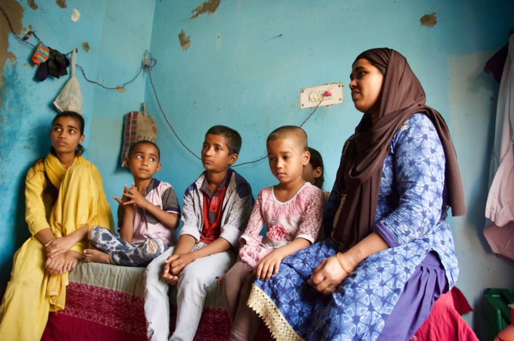 Shabnam and her five children sitting on a bed together