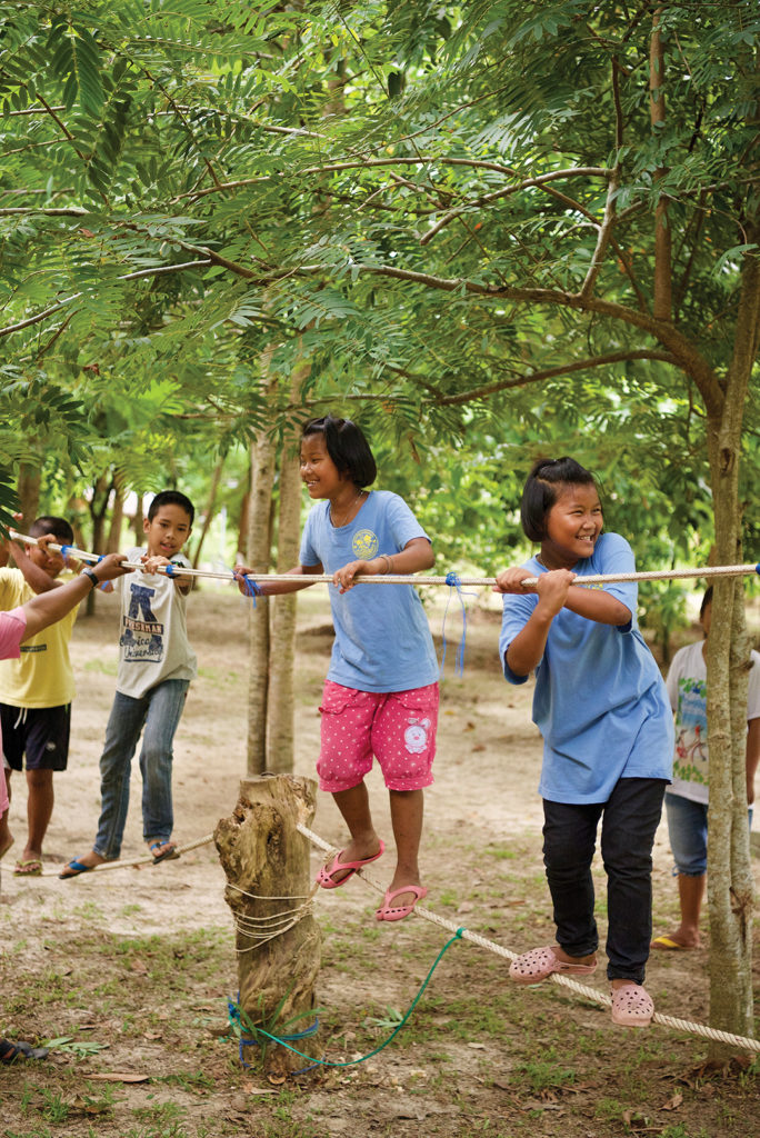 four children balancing on a rope bridge