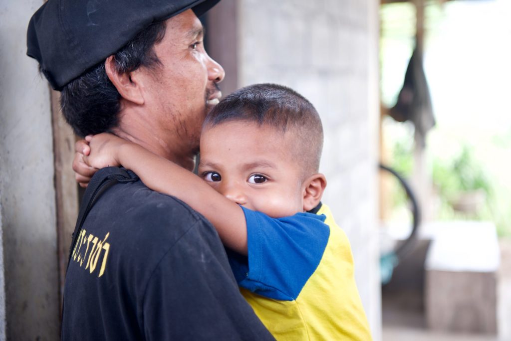 Anurak holding and hugging his son Kasem