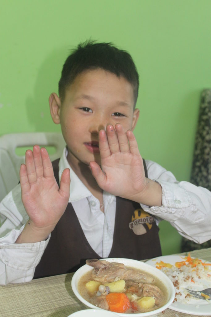 Munkh's hands are now completely healed! He is shown here holding up his hands.