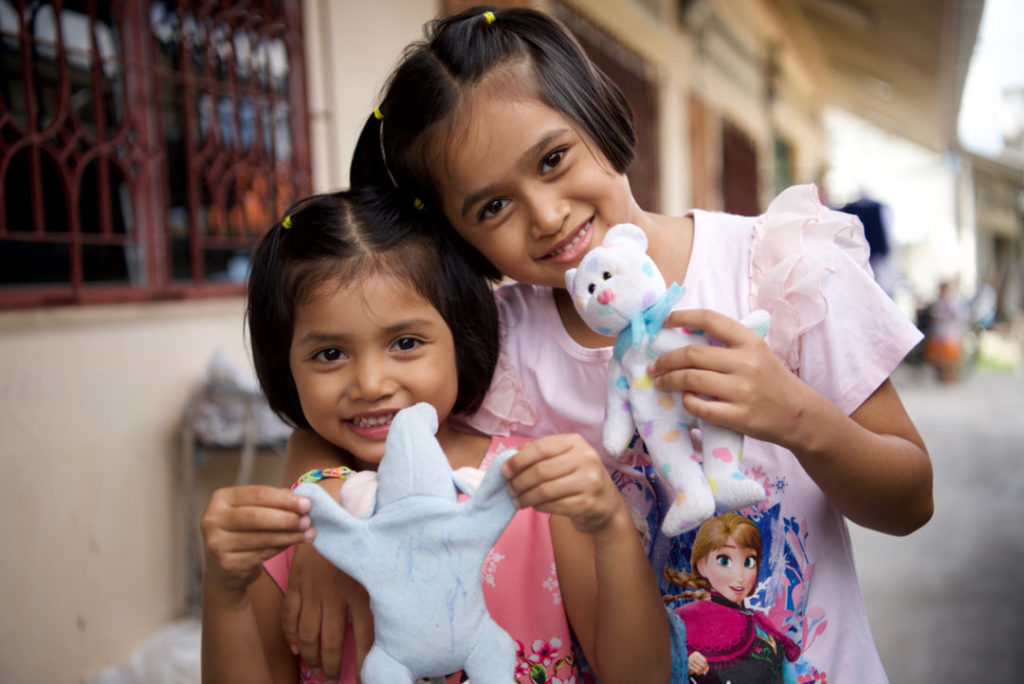 Nan and Mew posing with their stuffed animals.