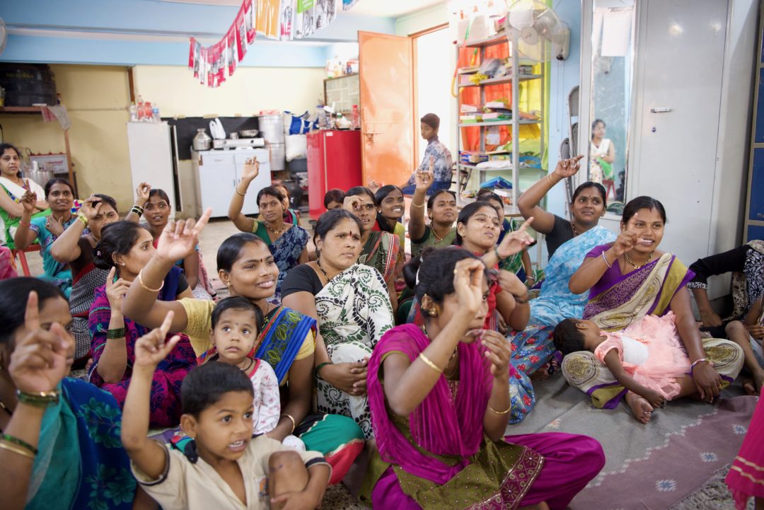 Mothers raise their hands to answer a question at the DEESHA.