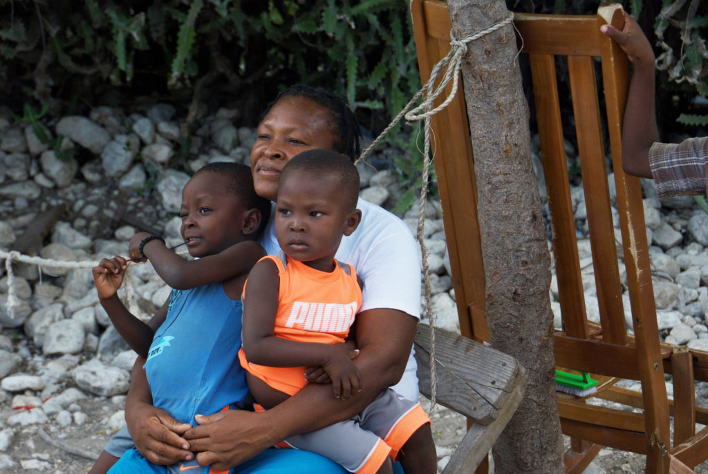 Claudette, who holds Jason and her youngest son in her lap, says the lunch her kids receive at school is important because she often has nothing to feed them in the morning. 