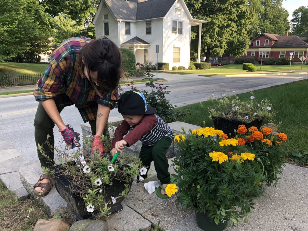 Micah helping his mom pot flowers. 