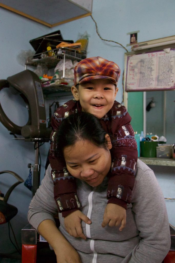 Sponsored family_Hung is smiling and hanging on his mother's back