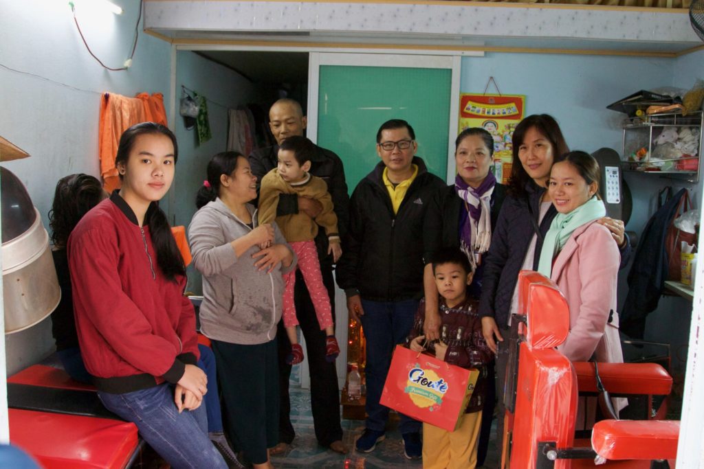 Vieng and her family stand beside their Holt social worker (in yellow shirt, center), officials from the local government and Holt Vietnam's in-country director, Hang Dam (second from right).