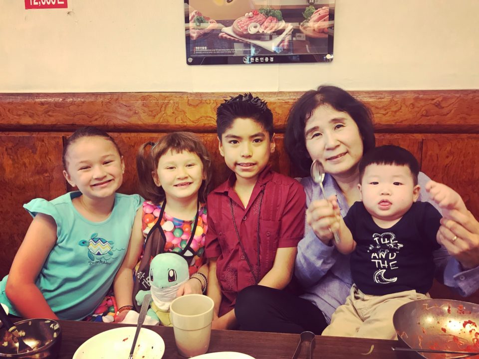 Joshua's foster mother shares a special moment with Joshua and his sisters, while her foster baby sits on her lap.