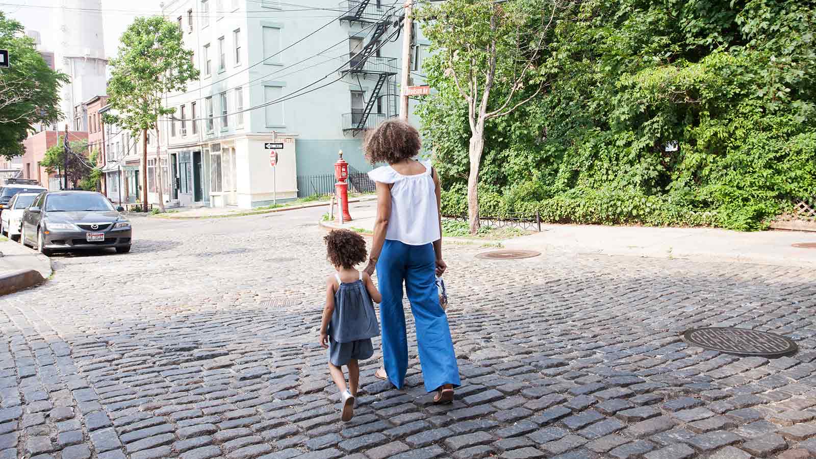 mother and daughter holding hands and walking down the street