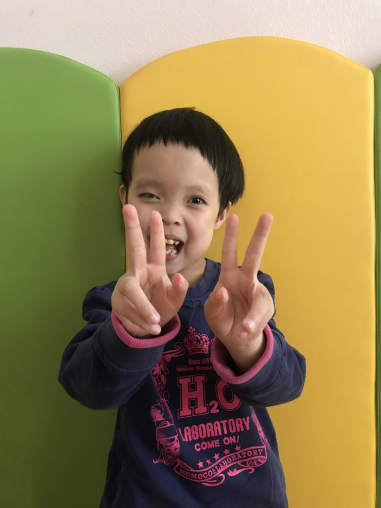 Denise, a child waiting for adoption, holding up her fingers to show how old she is