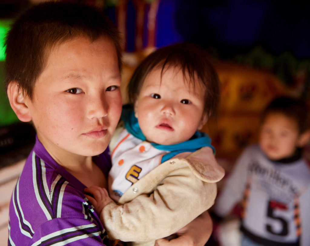 Munkhtulga holds his little sister inside his family's new ger. 