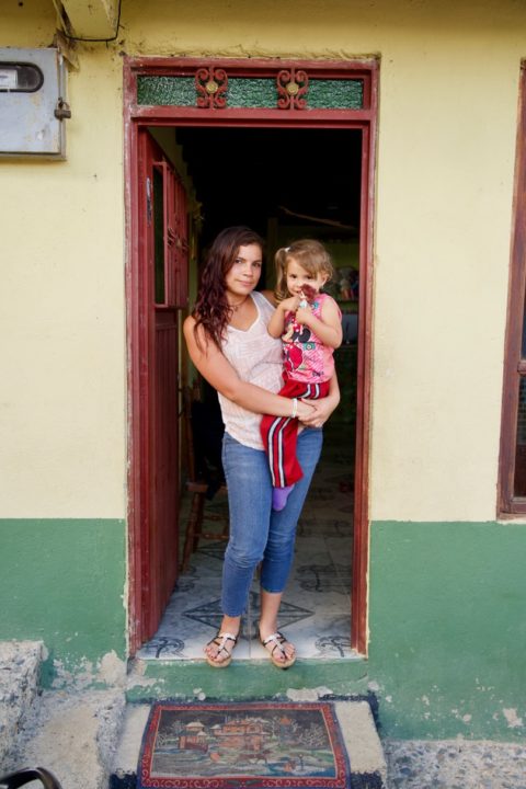 Monica holds her daughter, Yalena, as they stand in the doorway of their home in Darien.