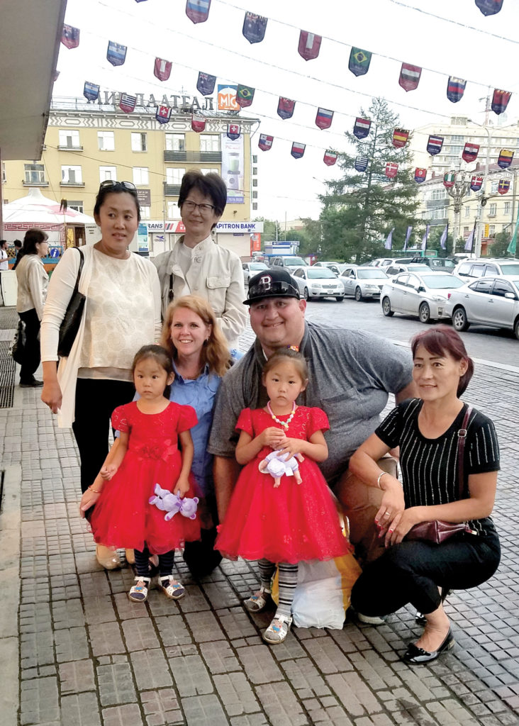 Jerrod and Melissa with her sponsored child, her sponsored child's twin sister, mom and Holt staff members in Ulaanbaatar.