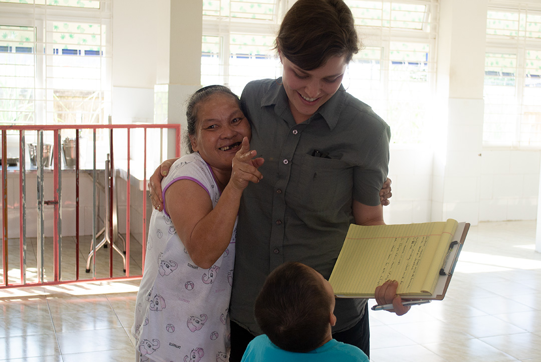 Emily with a caregiver and child in Vietnam.